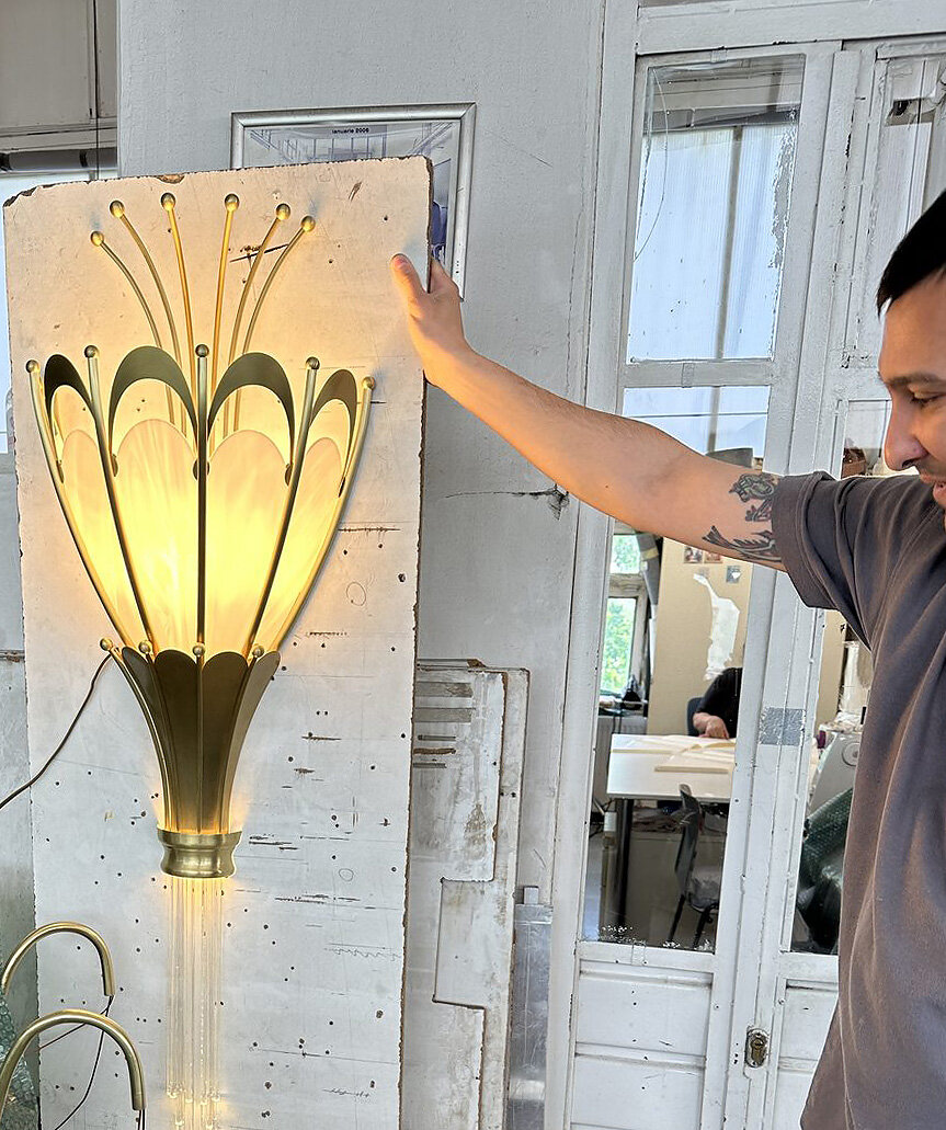 A lit Art Nouveau wall sconce, in the workshop