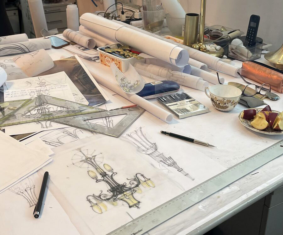 Drawing table with rolled sheets, sketches and brass parts