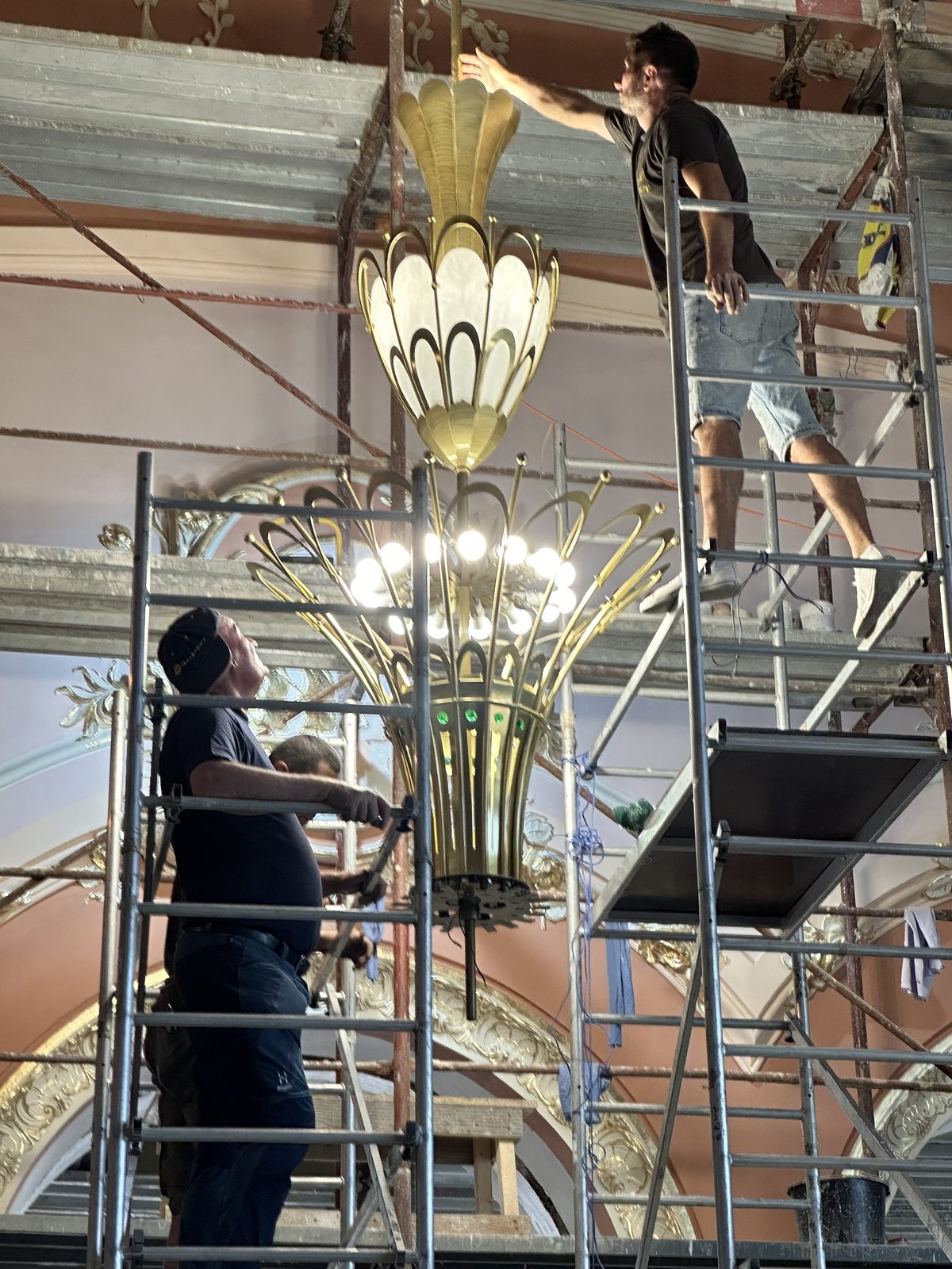 A chandelier hoisted on scaffolding, beneath the Casino ceiling