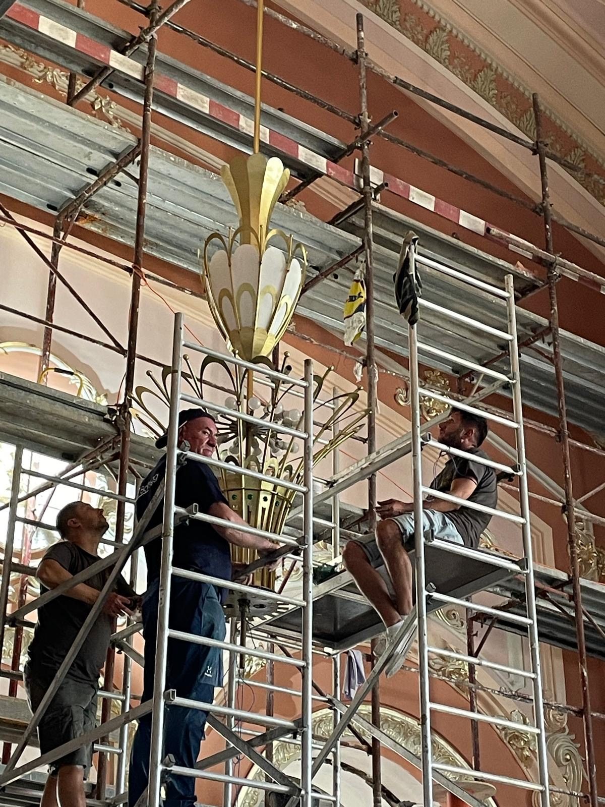 The team on scaffolding, installing a chandelier in the Constanța Casino
