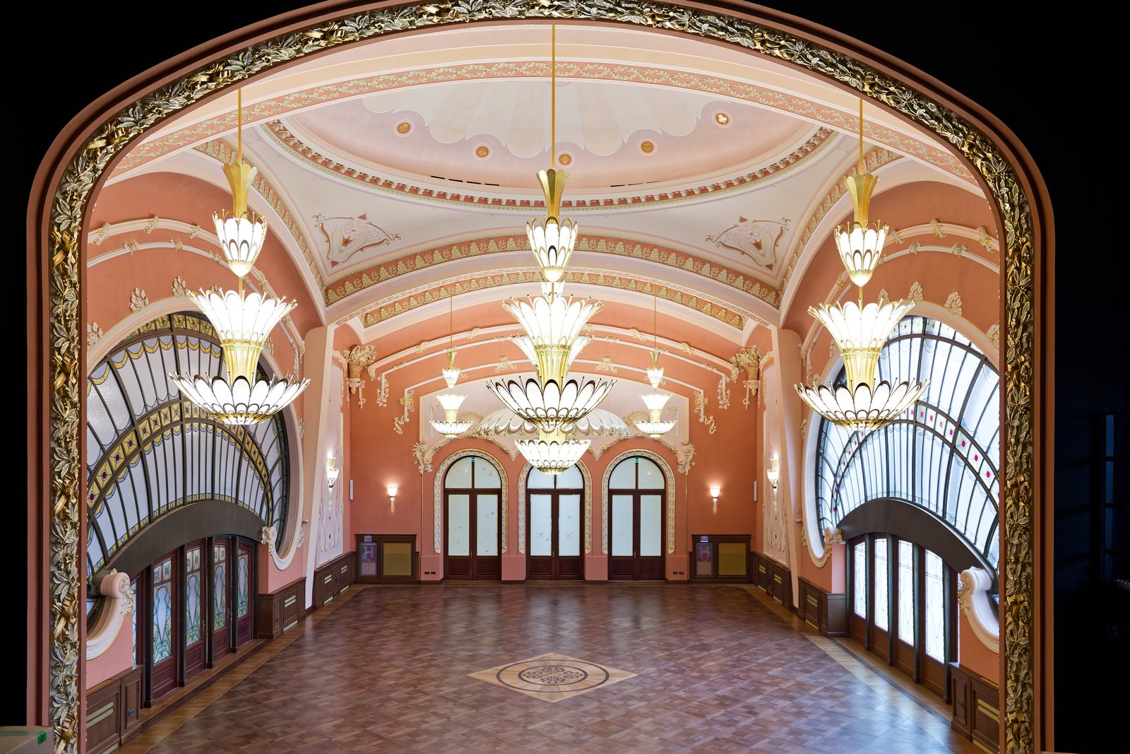 The Casino's great hall seen through the balcony arch, with the chandeliers lit