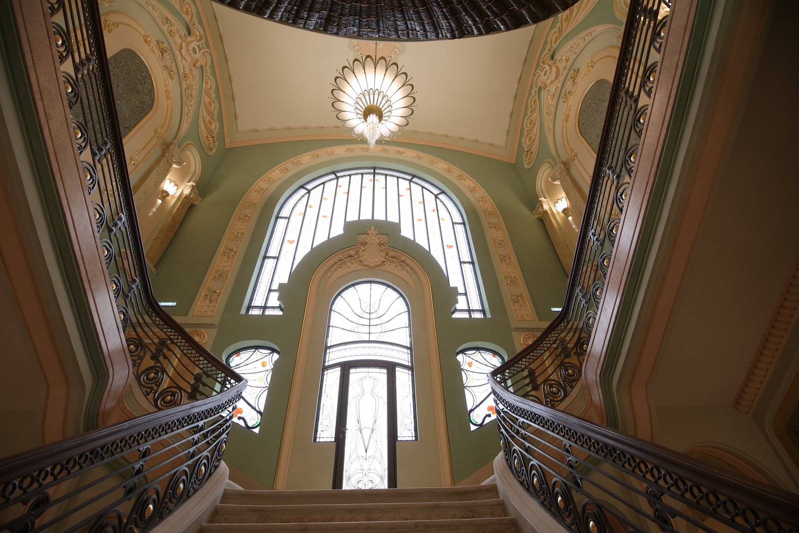 The Casino's grand staircase, with wrought-iron balustrades, chandelier and stained glass, seen from below