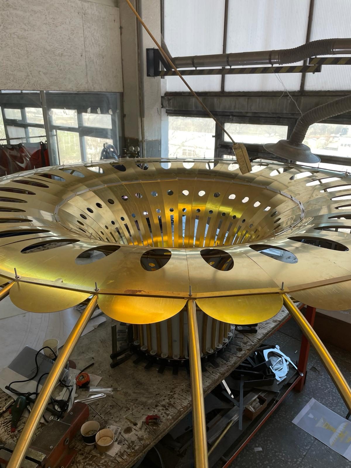 Circular brass structure of the large chandelier, in the workshop