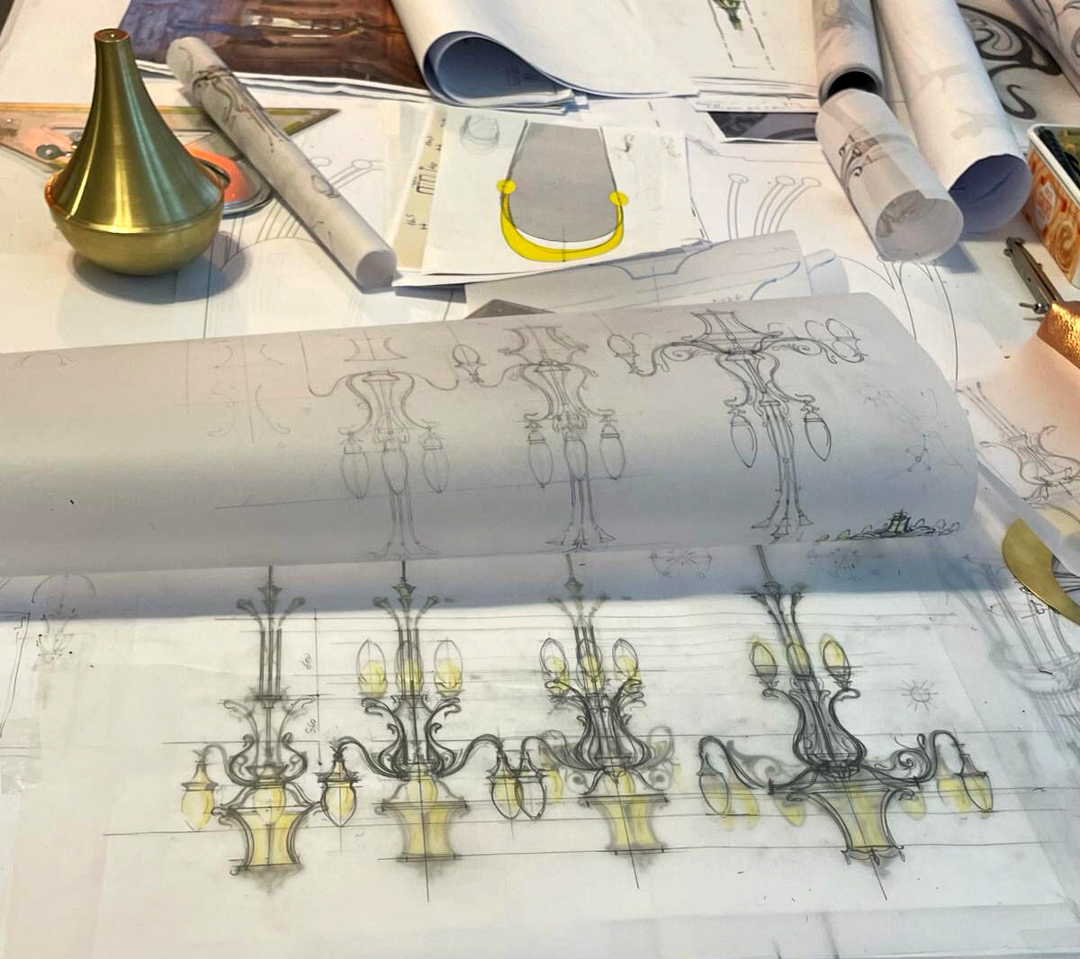 Four alternative sketches of an Art Nouveau sconce on the workbench