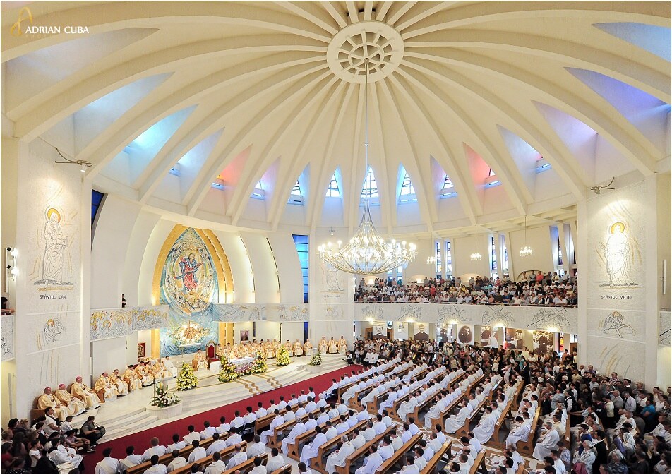 The interior of the Catholic Cathedral in Iași filled with worshippers, with the FD.STIL stainless steel chandelier hanging beneath the dome, above the altar and the mosaic of the Virgin Mary