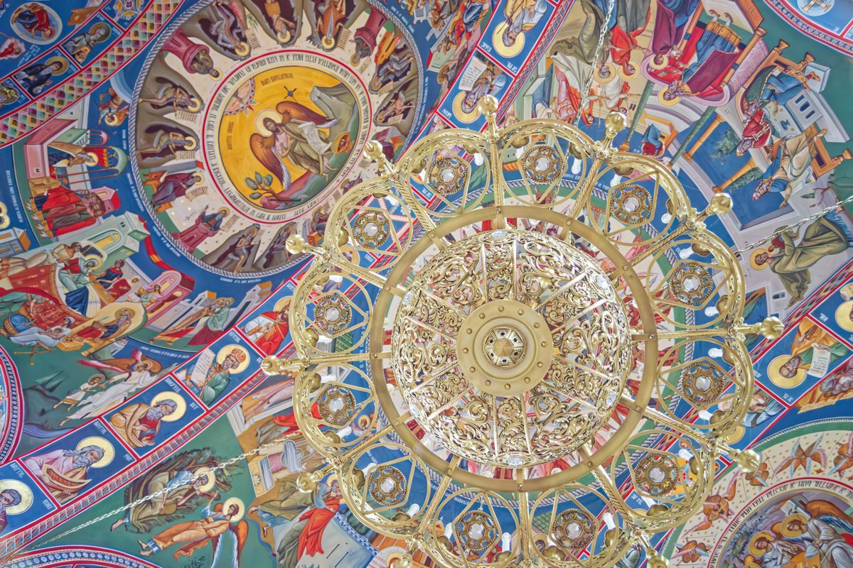 Looking up through the pierced basket of the chandelier, towards the painted dome of the church in Săpânța